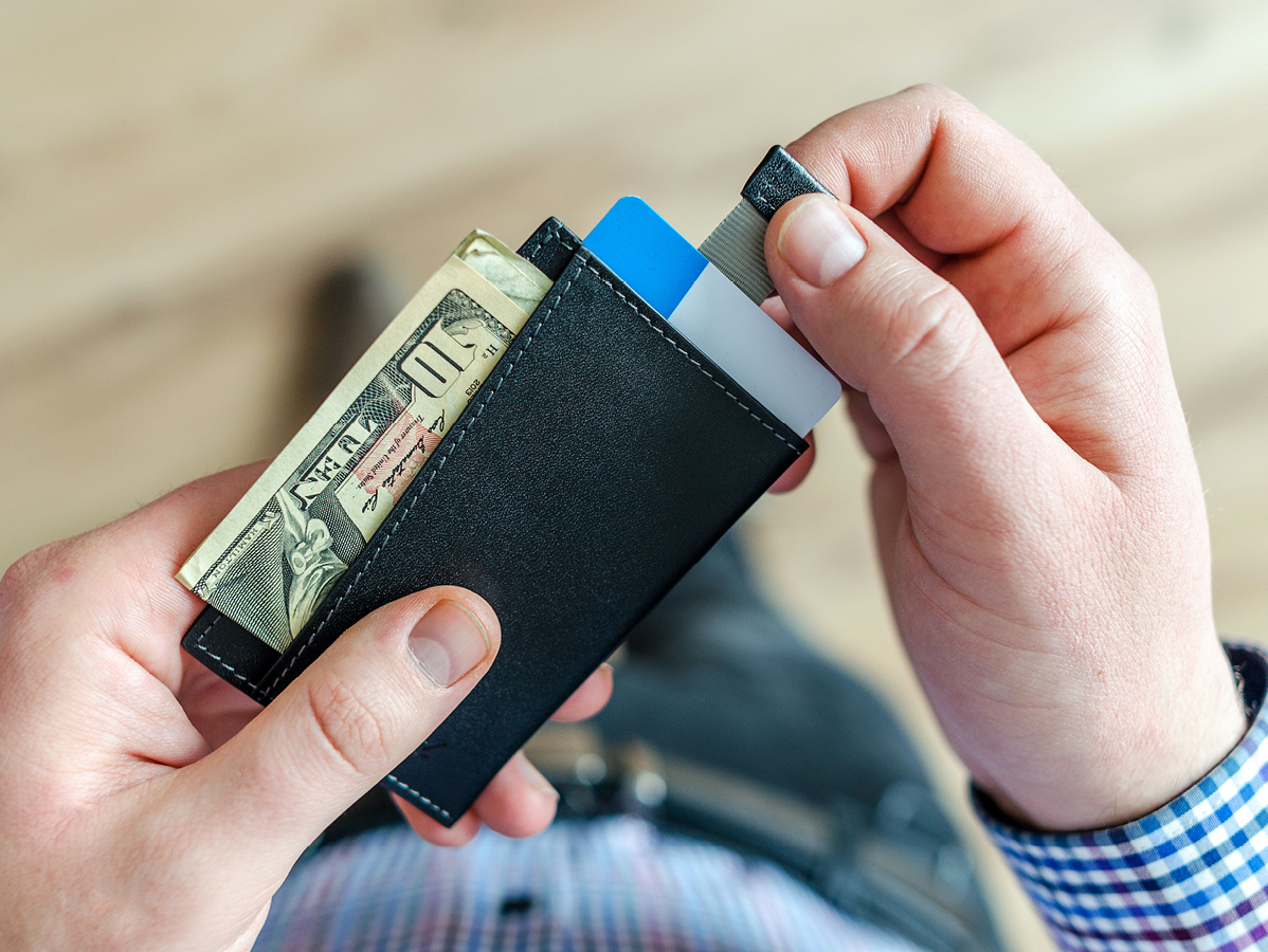 person holding wallet with cash