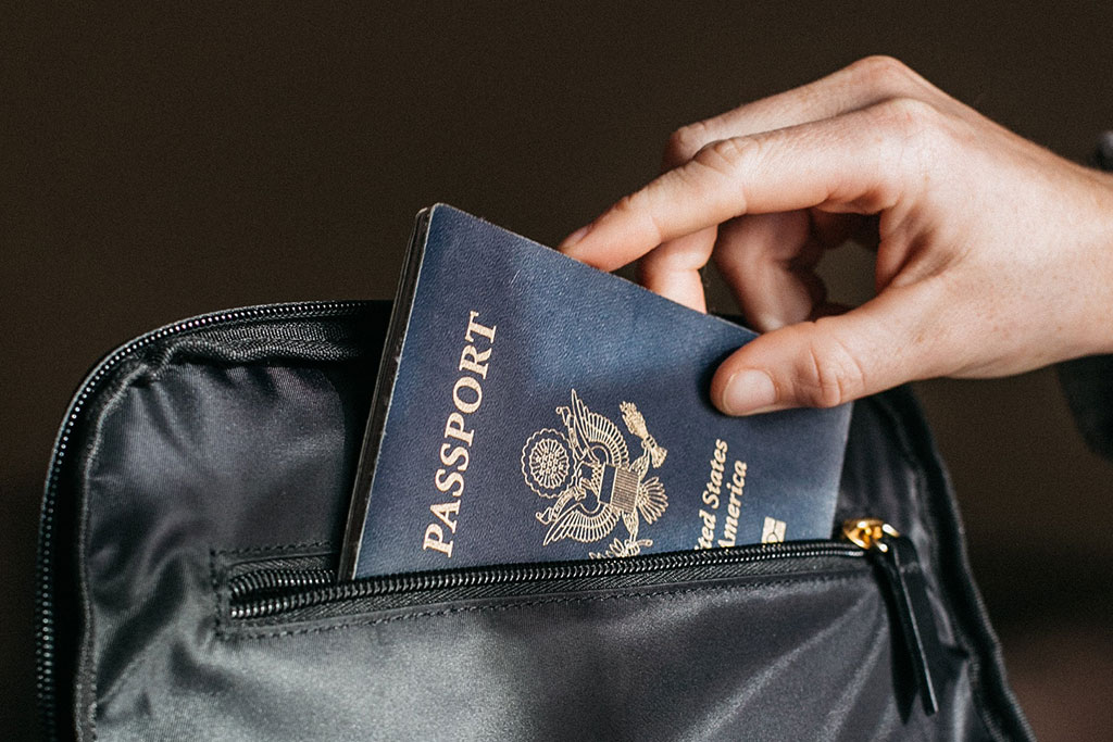 Person putting passport in bag