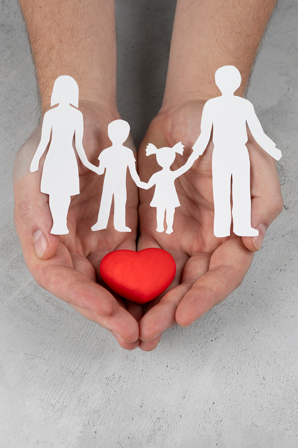 Person holding a cut out paper family and red heart