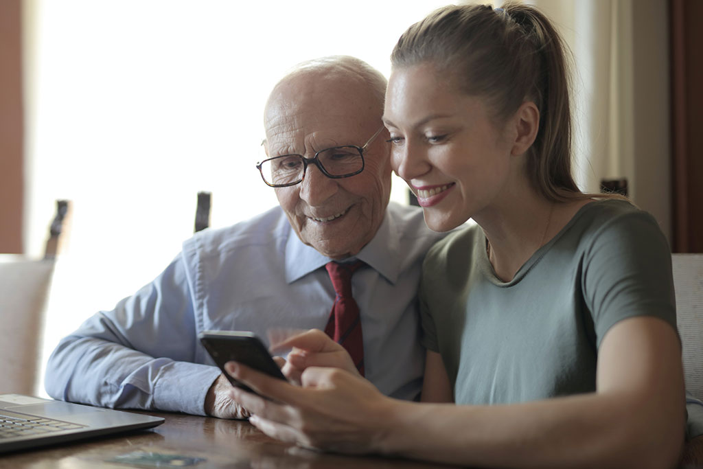Older man and daughter looking at phone