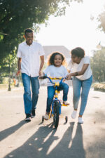 Parents helping daughter ride bike