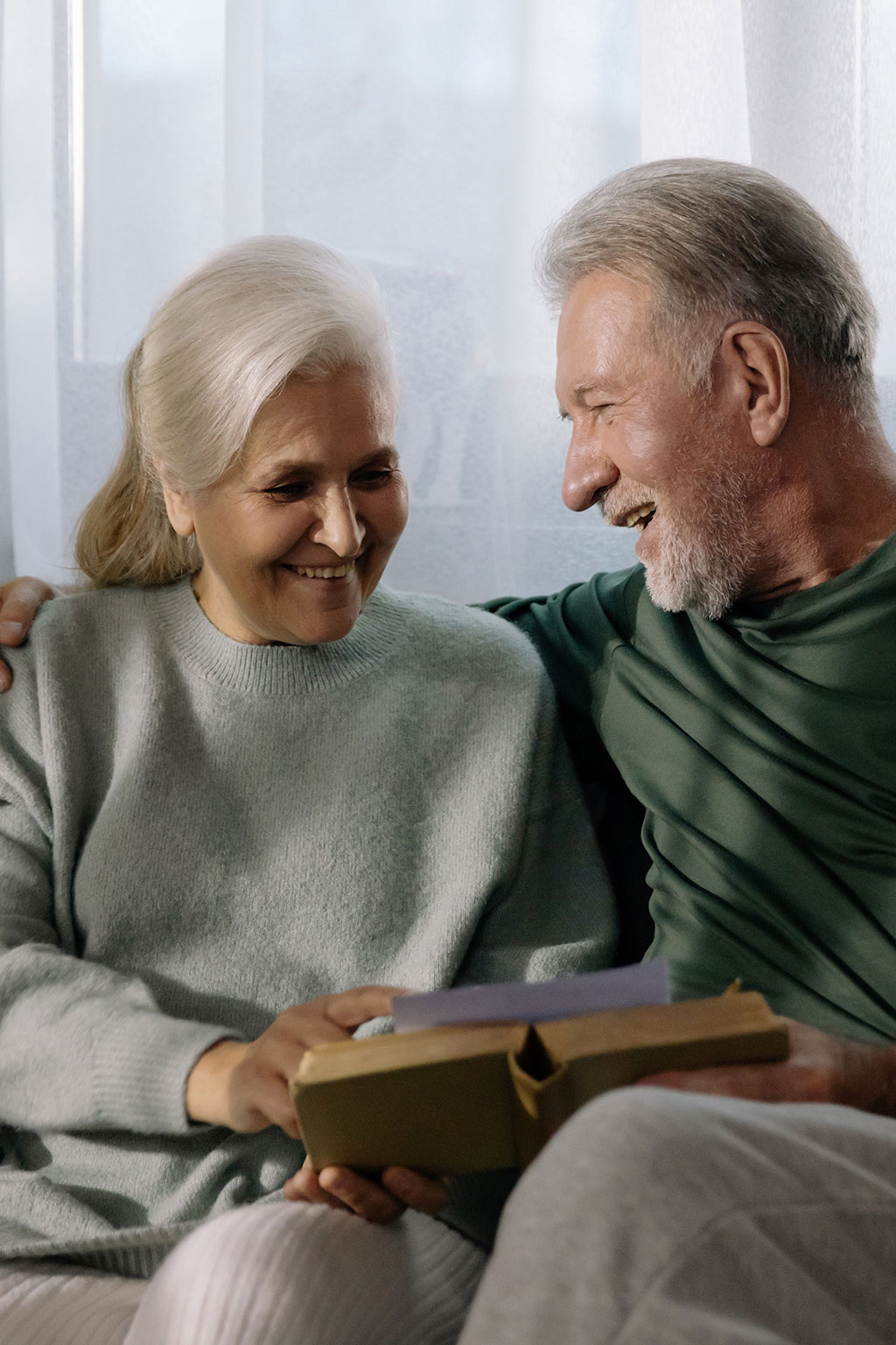 Older couple on couch looking at a book