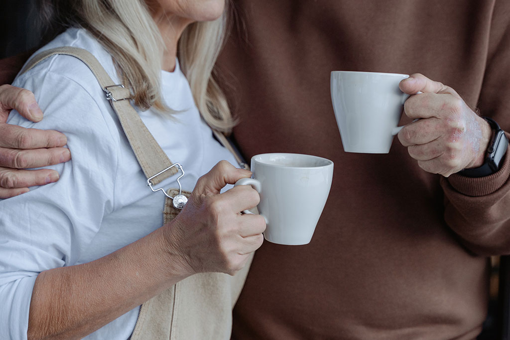 Older couple holding coffee mug
