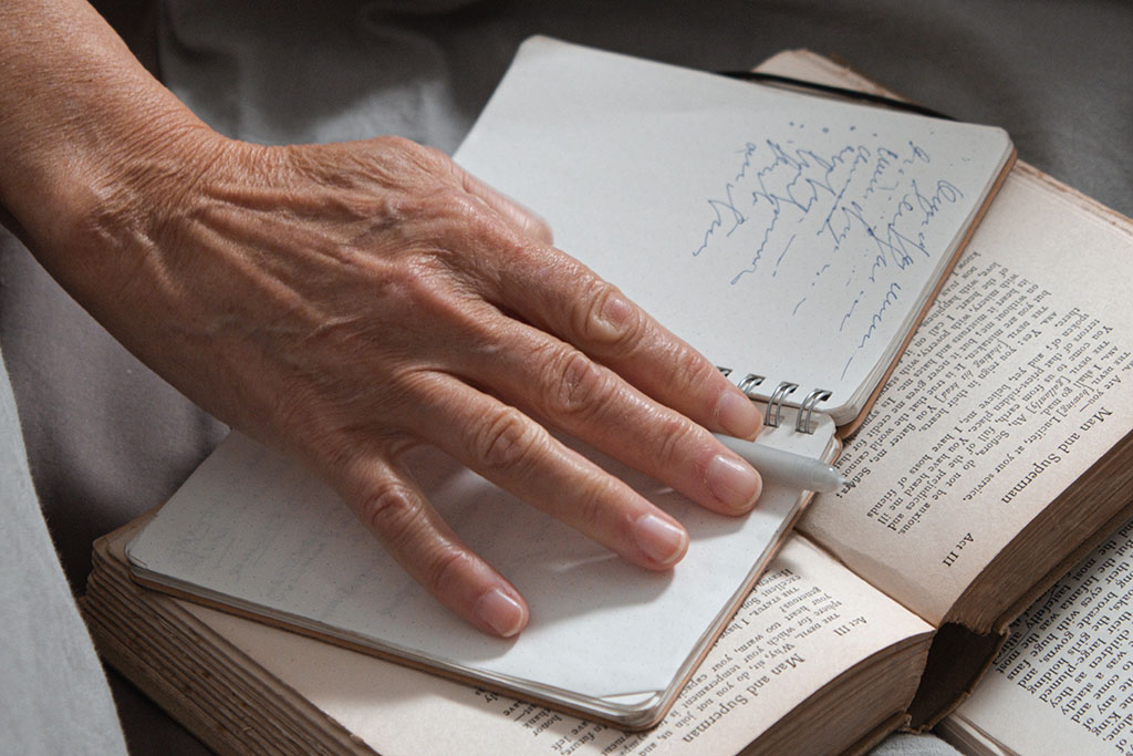 Older person writing in journal
