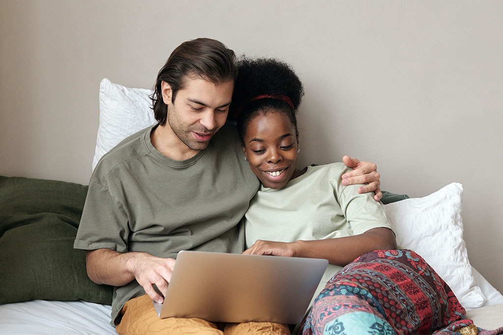 Couple in bed on laptop