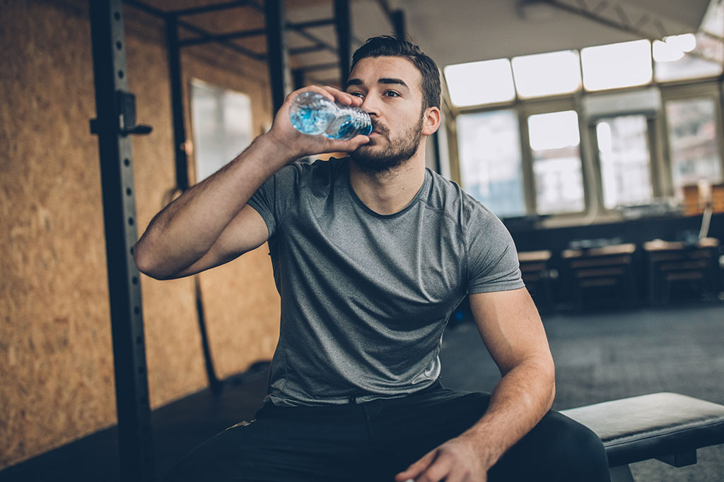 Man drinking water in a gym