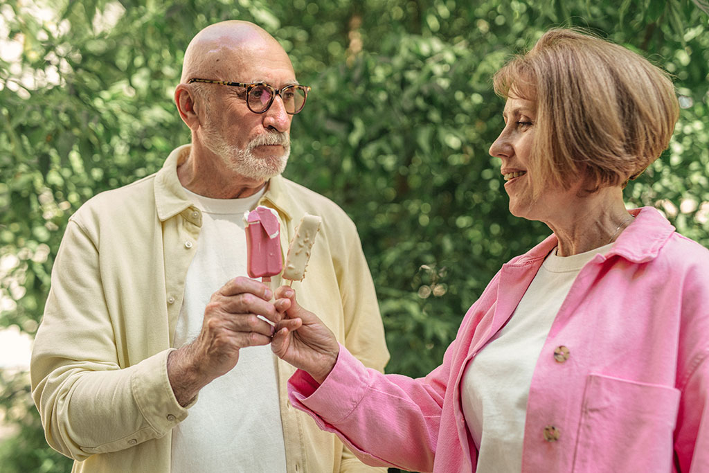 Older couple eating popsicle outside together