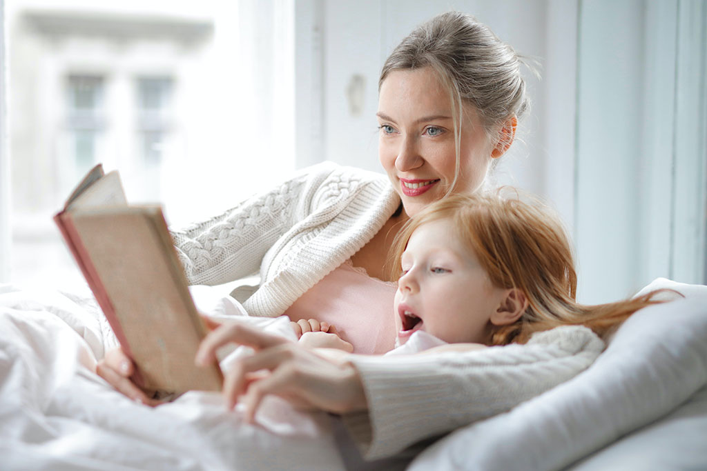 Mom reading book to daughter