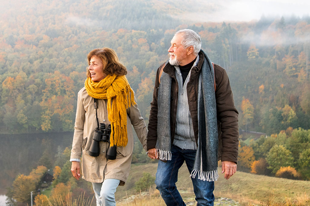 Older couple walking on hills