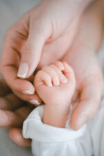 Parent holding new born hand