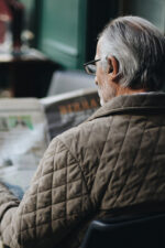 Man reading newspaper outside