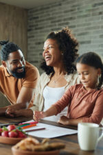 Younger family in kitchen looking over expenses