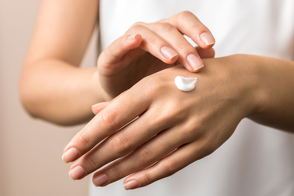 Woman putting lotion on hands