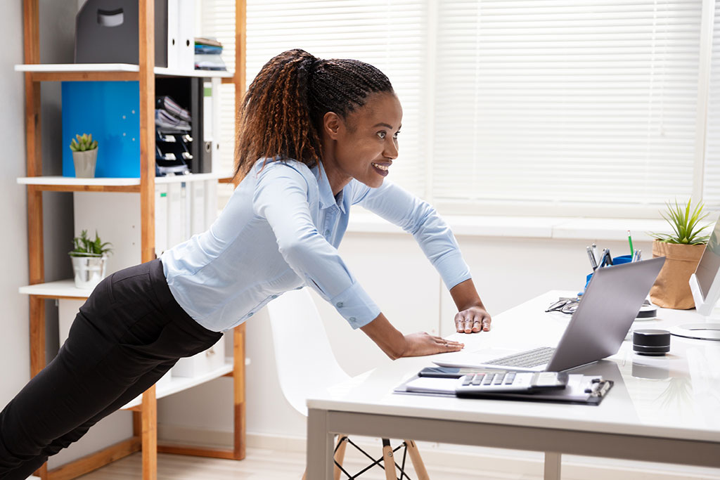 Women stretching at work at desk