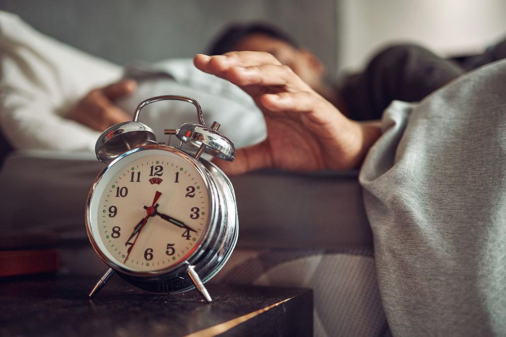 Person snoozing alarm clock