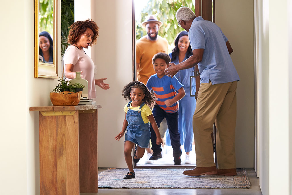 Family visting grandparents going into house