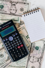 Money, calculator and notebook on desk
