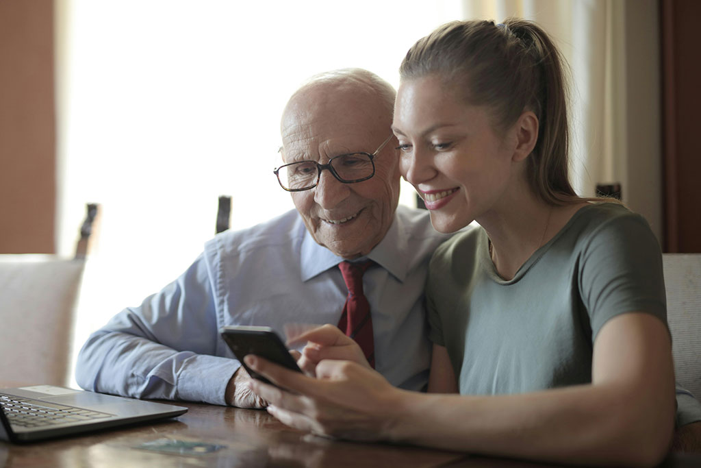 Grandpa and granddaughter looking over phone