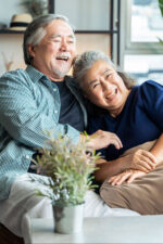 Older couple happy sitting on couch