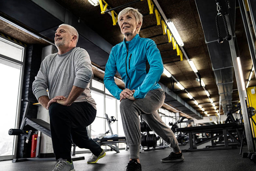 Old couple exercising in gym