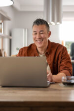 Man on laptop in kitchen