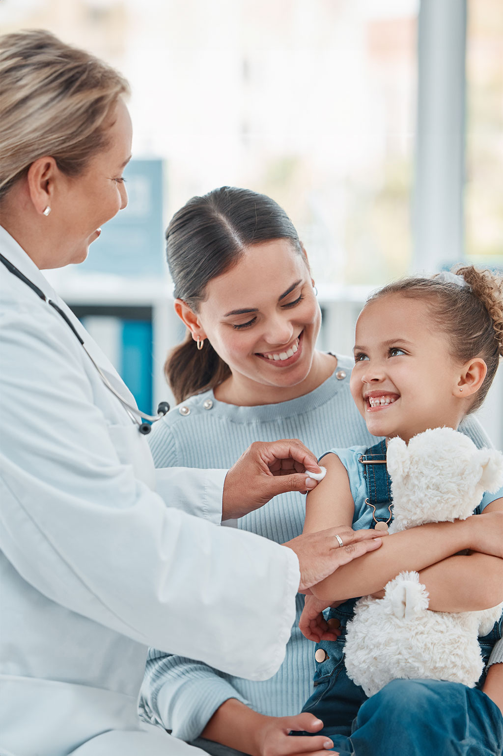 Family doctor attending daughter in mom's lap