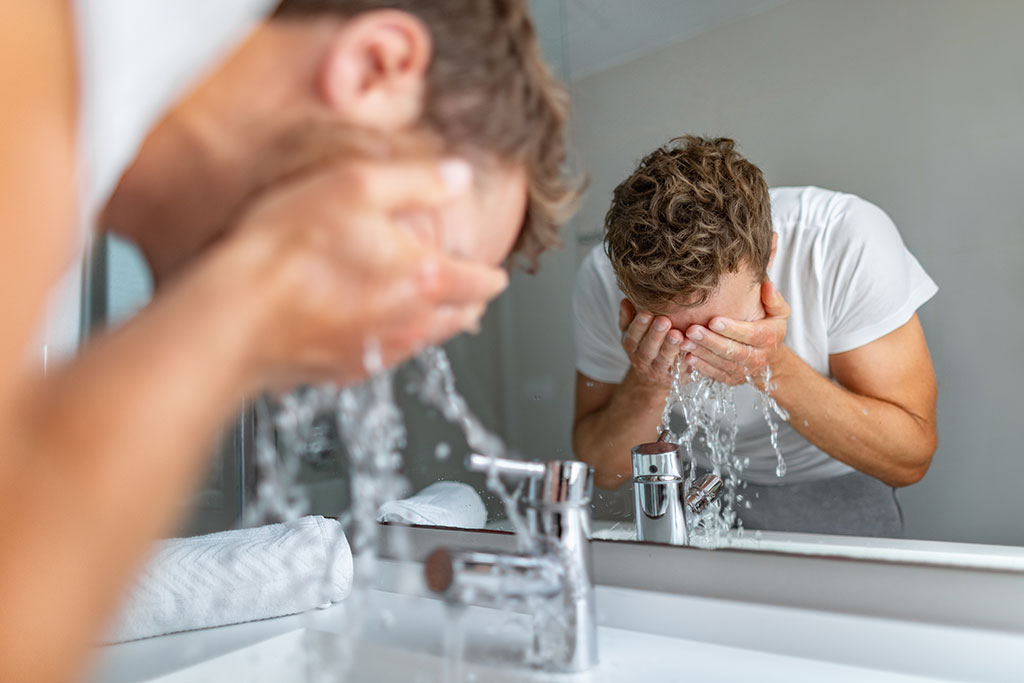 Uomo che si lava il viso