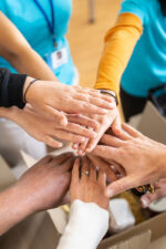 Volunteer team with hands in pile