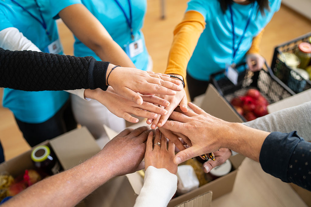 Volunteer team with hands in pile