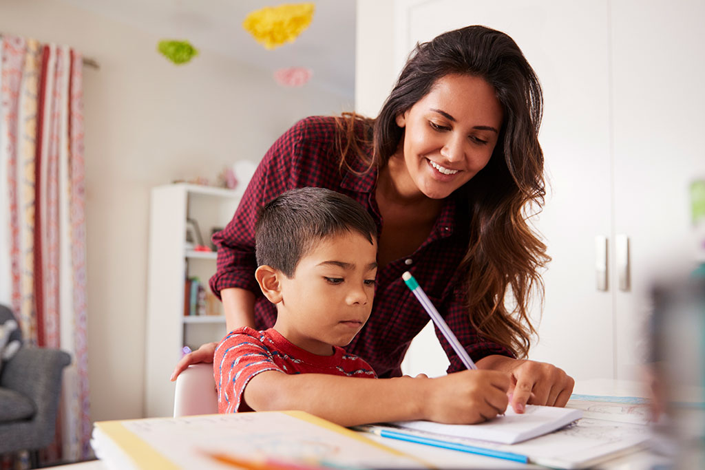 Mamma e figlio più piccolo che aiuta con i compiti