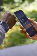 Person looking at fitness watch and stats on phone