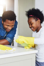 Dad and daughter cleaning kitchen counter