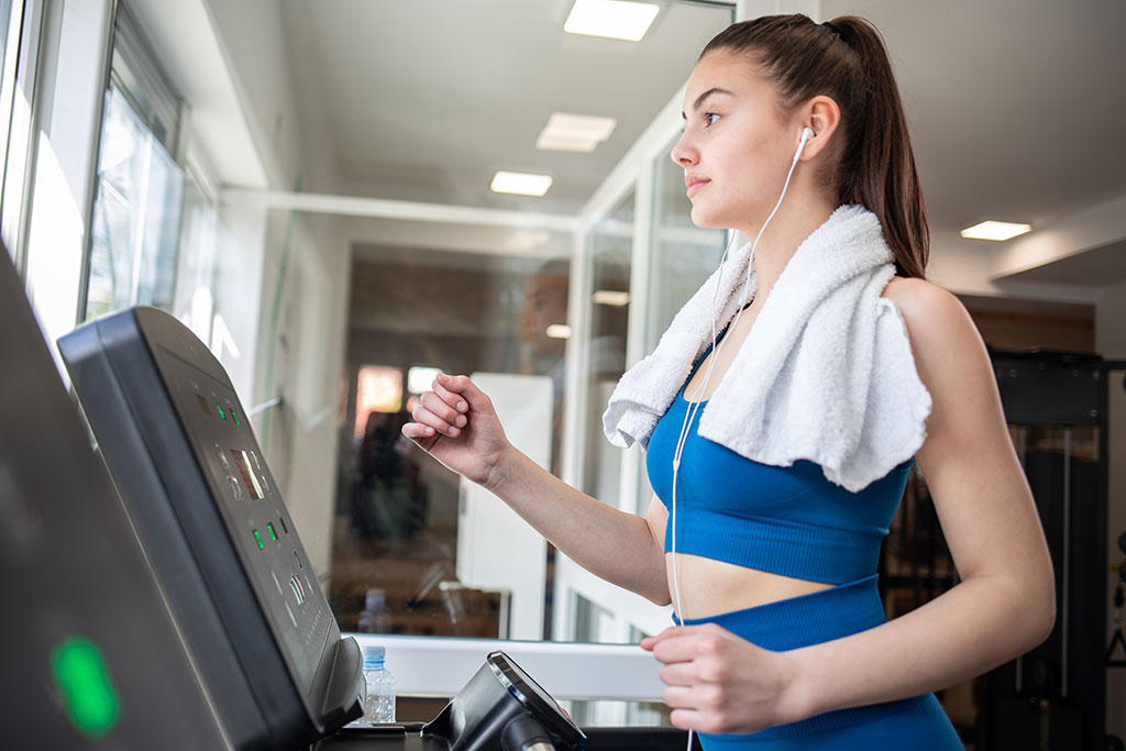 Woman on treadmill listening to audio book