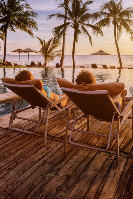 Couple relaxing by pool on vacation
