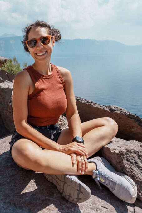Woman sitting at top of mountain