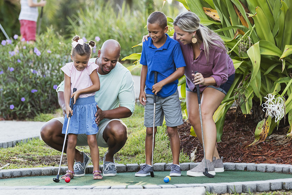 Family playing mini golf