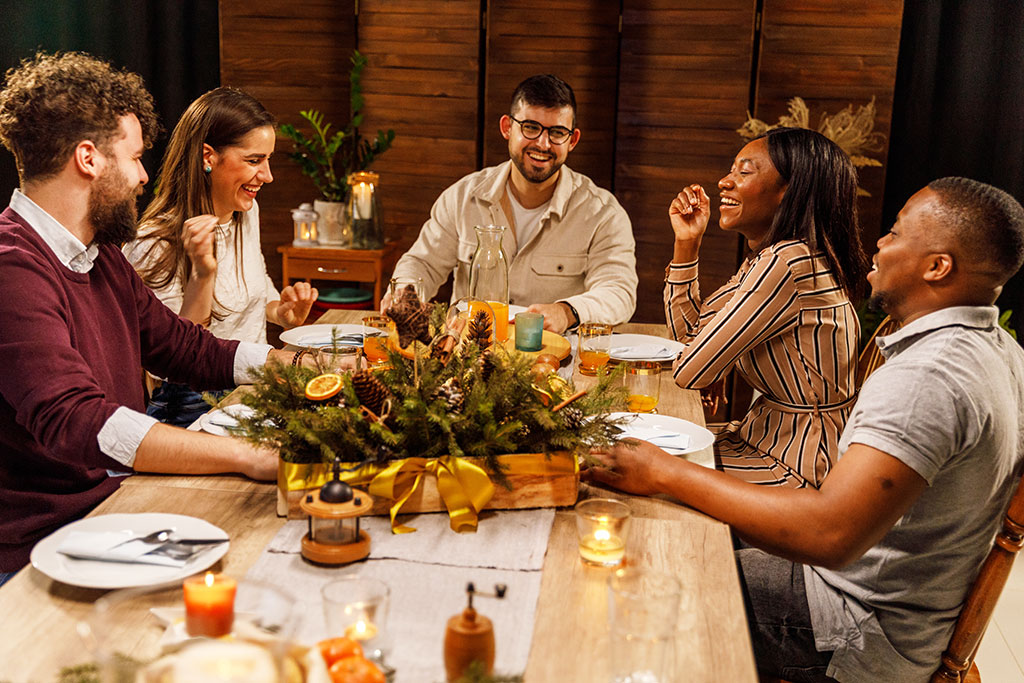 Friends eating at dinner table happy